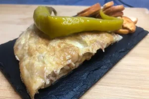 Pincho de tortilla de patatas acompañada de una guindilla