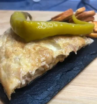 Pincho de tortilla de patatas acompañada de una guindilla