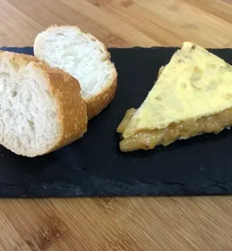 Tortilla de patatas poco cuajada y servida con unas rebanadas de pan