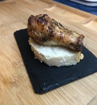 Tapa de alita de pollo asada al horno sobre rodaja de pan