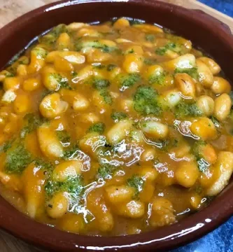 Alubias blancas con gambas o langostinos. En una cazuela de barro con salsa verde