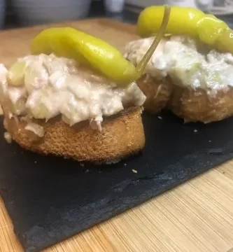 Tapa de ensaladilla rusa sobre pan tostado y coronada con una guindilla