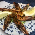 Gambas cocinadas a la plancha con limón y ajo perejil.