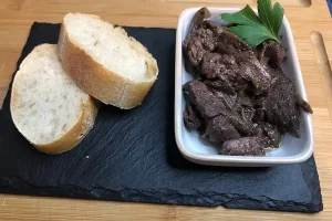 Hígado encebollado y desglasado con vino tinto.