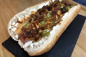 Perrito caliente con cebolla caramelizada